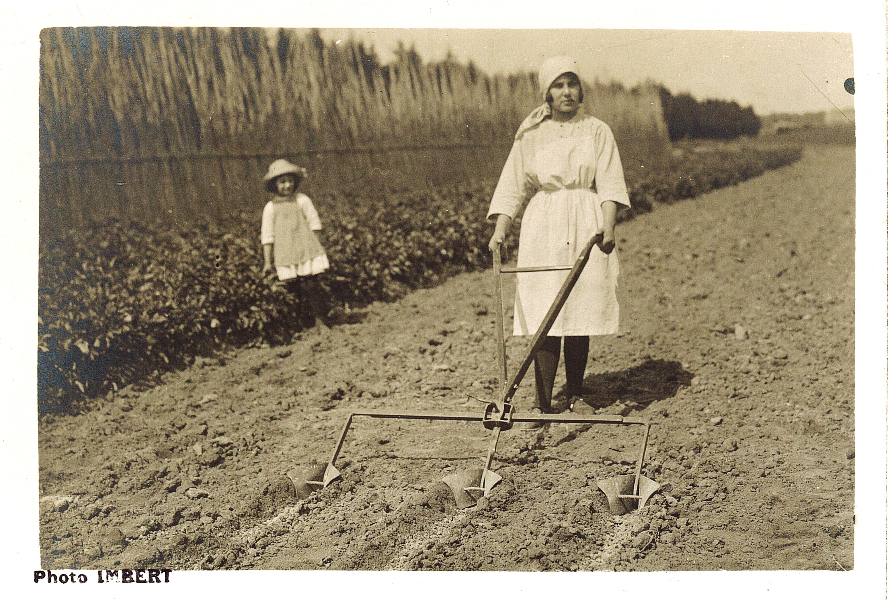 femme labourant la terre petite fille à côté photo ancienne